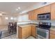 Efficient kitchen with stainless appliances, wood cabinets, and adjacent dining area for easy meal service at 295 N Rural Rd # 143, Chandler, AZ 85226
