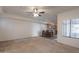 Spacious living room with carpet flooring, ceiling fan, and a glimpse into the kitchen with dining table at 295 N Rural Rd # 143, Chandler, AZ 85226