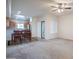 Open living and dining space with a wooden dining set, kitchen view, and carpeted living area at 295 N Rural Rd # 143, Chandler, AZ 85226