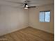 An empty bedroom with light colored walls, wood floor and a ceiling fan at 3104 E Broadway Rd # 207, Mesa, AZ 85204
