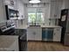 Modern kitchen with stainless steel appliances, white cabinetry, and a sink beneath a window at 3104 E Broadway Rd # 207, Mesa, AZ 85204