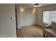 Well-lit living room with wood-look flooring, a window, and a glimpse of comfortable seating at 3104 E Broadway Rd # 207, Mesa, AZ 85204