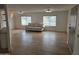 Spacious living room featuring wood-look floors, two large windows, and comfortable seating at 3104 E Broadway Rd # 207, Mesa, AZ 85204