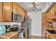 A cozy kitchen featuring tan cabinets, granite countertops, and modern stainless steel appliances at 3500 N Hayden Rd # 203, Scottsdale, AZ 85251