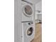 Modern stacked washer and dryer units in a bright laundry closet, conveniently located near the living area at 3500 N Hayden Rd # 203, Scottsdale, AZ 85251