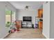 A bright living room featuring a tv, modern ceiling fan, and indoor plants by a sunlit window at 3500 N Hayden Rd # 203, Scottsdale, AZ 85251