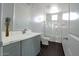 A bright bathroom with a modern vanity, marble countertops, and a shower-tub combo at 35672 W Chipman Rd, Tonopah, AZ 85354