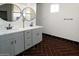 Modern bathroom with double vanity, sleek fixtures, and stylish herringbone flooring at 35672 W Chipman Rd, Tonopah, AZ 85354