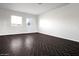 A spacious bedroom with natural light from two windows and stylish herringbone flooring at 35672 W Chipman Rd, Tonopah, AZ 85354