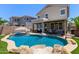 Large in-ground pool in backyard featuring rock accents and a lounging area at 3692 N 292Nd Dr, Buckeye, AZ 85396