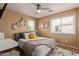 Bright bedroom with gray bedframe, floral decor, and ceiling fan at 3692 N 292Nd Dr, Buckeye, AZ 85396