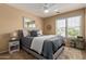 Cozy bedroom features a ceiling fan, a gray bed frame and a matching gray textured comforter at 3692 N 292Nd Dr, Buckeye, AZ 85396