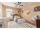 Bright bedroom with floral bedding, large rug, ceiling fan, and charming decor at 3692 N 292Nd Dr, Buckeye, AZ 85396