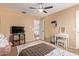 Cozy bedroom with a ceiling fan, TV, vanity and a view into the hallway at 3692 N 292Nd Dr, Buckeye, AZ 85396