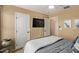 Warm bedroom with TV features neutral walls, white trim, and gray bedding with quilted blanket at 3692 N 292Nd Dr, Buckeye, AZ 85396