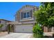 Exterior view of a two-story home with a stone-accented facade, two-car garage, and neat landscaping in a sunny setting at 3692 N 292Nd Dr, Buckeye, AZ 85396