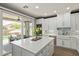 Bright kitchen with an island, stainless steel appliances, and sliding glass doors to the pool at 3692 N 292Nd Dr, Buckeye, AZ 85396