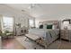 Spacious main bedroom with wood-look floors, bench, and seating area at 3692 N 292Nd Dr, Buckeye, AZ 85396