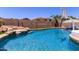 Beautiful pool with rock waterfall feature, basketball hoop, and lush landscaping at 3692 N 292Nd Dr, Buckeye, AZ 85396