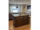Kitchen island with dark wood cabinets, granite countertops, and pendant lighting at 4020 N 44Th Pl, Phoenix, AZ 85018