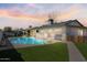 Backyard featuring a pool, artificial grass, covered patio, and outdoor bar at 4415 S Poplar St, Tempe, AZ 85282