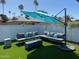 Relaxing backyard with outdoor seating, a fire pit, lush lawn, and tall palm trees at 4415 S Poplar St, Tempe, AZ 85282