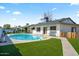 Inviting backyard pool with a patio seating area, synthetic grass and a view of the home's exterior at 4415 S Poplar St, Tempe, AZ 85282