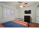 Bedroom featuring window, ceiling fan, mounted tv, and wood-look floors at 4415 S Poplar St, Tempe, AZ 85282