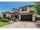 Attractive stucco home featuring a brick facade, two-car garage, and green lawn at 4463 S Oregon Ct, Chandler, AZ 85248