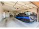 Spacious and organized three car garage with overhead lighting, storage units, and covered vehicle at 4463 S Oregon Ct, Chandler, AZ 85248