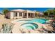 Private backyard features a sparkling pool and spa surrounded by tasteful landscaping and secure fencing at 4520 N 151St Dr, Goodyear, AZ 85395