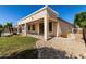 Backyard view showcasing a covered patio with access to the grassy lawn and well maintained landscaping at 4520 N 151St Dr, Goodyear, AZ 85395