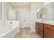 Bright bathroom with a soaking tub, separate glass-enclosed shower, and a dual-sink vanity at 4520 N 151St Dr, Goodyear, AZ 85395