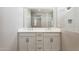 Bathroom with double vanity, framed mirror, and white cabinets for ample storage at 5815 E Covey Ln, Phoenix, AZ 85054