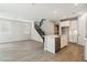 Open floor plan featuring tile floors, kitchen with island, staircase with iron railing, and natural light at 5815 E Covey Ln, Phoenix, AZ 85054
