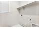 Functional laundry room featuring ample shelving, utility connections, and a bright, clean interior at 5819 E Covey Ln, Phoenix, AZ 85054