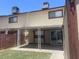 View of the back of a tan townhome featuring a concrete patio and small yard at 6029 N 31St Ave, Phoenix, AZ 85017