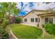 Beautiful backyard featuring a well-manicured lawn, mature trees, and a covered patio area at 6300 S Nash Way, Chandler, AZ 85249
