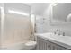 Bright bathroom with a tub and shower combo, and grey vanity with a white sink at 6300 S Nash Way, Chandler, AZ 85249