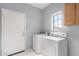Functional laundry room with a window, cabinets, and full-size washer and dryer at 6300 S Nash Way, Chandler, AZ 85249