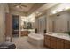 A luxurious bathroom features a soaking tub, dual sinks, and plantation shutters for a spa-like experience at 6481 E Amber Sun Dr, Scottsdale, AZ 85266