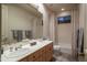Bathroom boasts dual sinks, framed mirror, and a shower/tub combo, exuding both comfort and functionality at 6481 E Amber Sun Dr, Scottsdale, AZ 85266