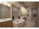 Luxurious bathroom featuring double vanity, and a jacuzzi bathtub at 6481 E Amber Sun Dr, Scottsdale, AZ 85266