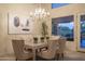 This elegant dining room is illuminated by a stylish chandelier and flooded with natural light at 6481 E Amber Sun Dr, Scottsdale, AZ 85266