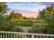 Scenic golf course view with lush green fairway, mature trees, and sand traps against a colorful twilight sky at 6481 E Amber Sun Dr, Scottsdale, AZ 85266