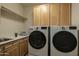 Convenient laundry room with a sink, storage cabinets, and modern washer and dryer units at 6481 E Amber Sun Dr, Scottsdale, AZ 85266