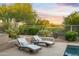 Relaxing patio featuring lounge chairs with plush cushions, desert landscaping, and a view of the golf course at 6481 E Amber Sun Dr, Scottsdale, AZ 85266