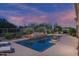 Backyard pool features desert landscaping, a rock water feature, and plenty of space for outdoor seating at 6481 E Amber Sun Dr, Scottsdale, AZ 85266