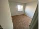Simple bedroom space featuring soft carpet and a large window for natural light at 6911 W Devonshire Ave # 1269, Phoenix, AZ 85033