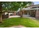 Spacious backyard featuring a covered patio, lush lawn, and mature trees, perfect for outdoor living at 8219 S Pecan Grove Cir, Tempe, AZ 85284